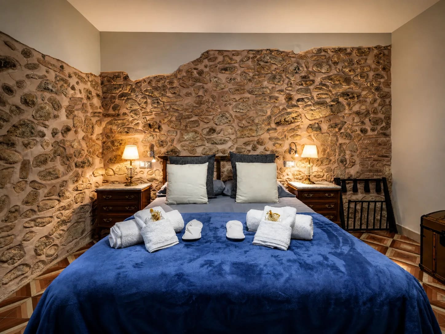 Habitación L'Alzina con cama de matrimonio, paredes de piedra y vigas de madera